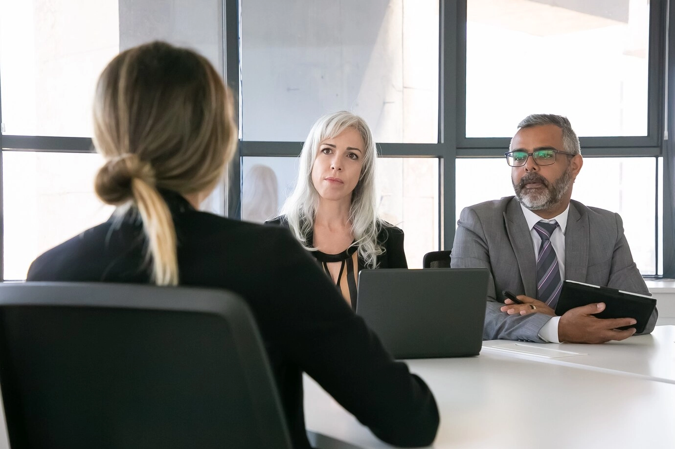 Serious employer and HR manager talking to job candidate at interview